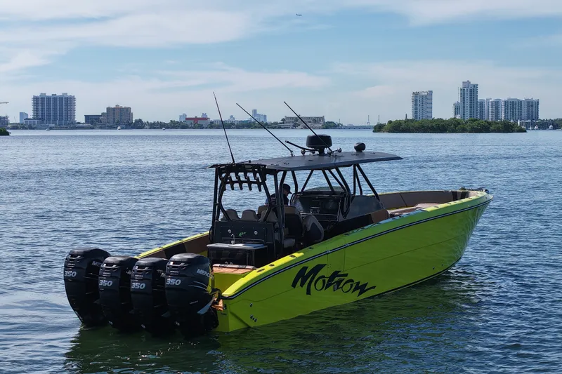 Slide: The Image of 2016 Midnight Express 43 Open boat with four engines on a calm waterway. - 2