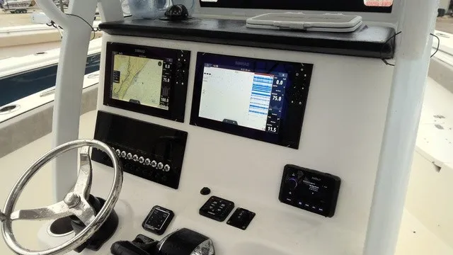 Slide: The Image of The image shows the helm of a Sea Pro 262 Center Console boat with modern navigation systems. - 11