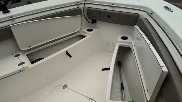 Slide: The Image of The image shows the bow area of a 2024 Sea Pro 262 Center Console boat with storage compartments. - 14