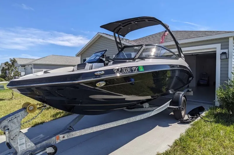 The Image of 2024 Yamaha Boats AR195 on trailer, parked in driveway near garage. - 0
