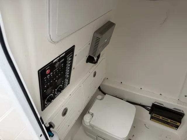Slide: The Image of Interior view of a 2024 Sea Pro 262 Center Console boat with controls and a toilet. - 15