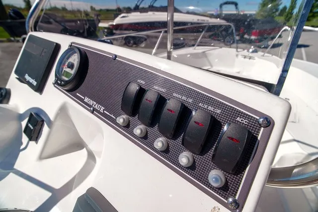 Slide: The Image of Close-up of a 2022 Boston Whaler 170 Montauk console with multiple switches. - 14
