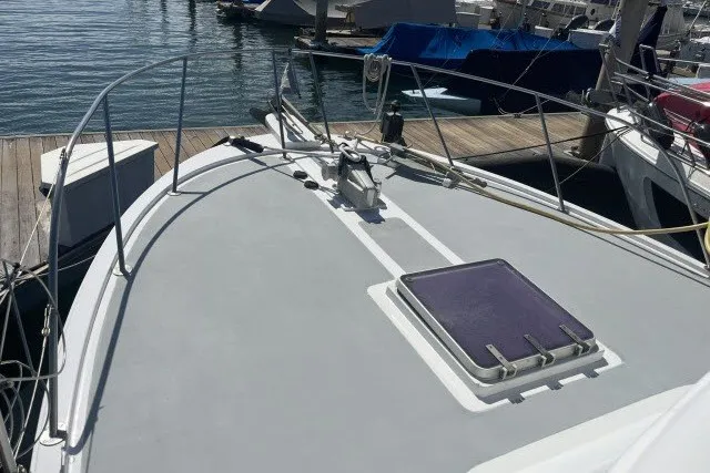 Slide: The Image of 1983 Roughwater 41 boat deck at marina, featuring hatch and railing. - 35