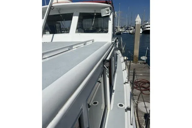 Slide: The Image of 1983 Roughwater 41 boat docked at marina, showcasing deck and cabin details. - 33
