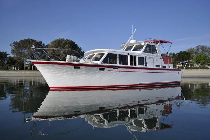 Slide: The Image of 1983 Roughwater 41 boat on calm water, featuring a white and red design. - 45