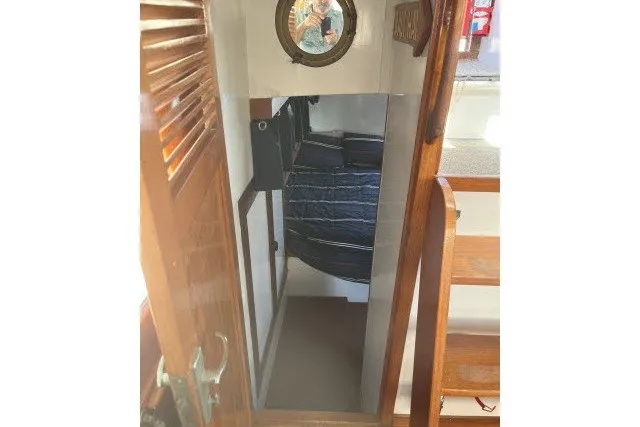 Slide: The Image of Interior view of 1983 Roughwater 41 boat cabin with wooden stairs and porthole. - 15