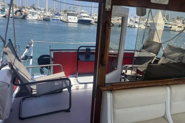 Slide: The Image of 1983 Roughwater 41 yacht interior with marina view, featuring seating and nautical equipment. - 28