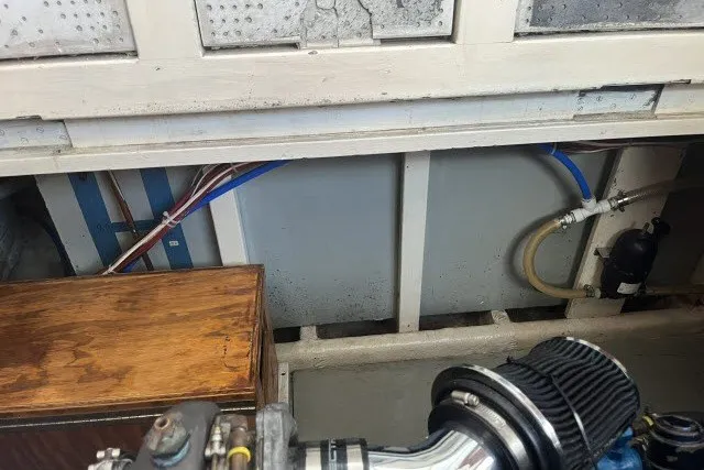 Slide: The Image of Engine compartment of a 1983 Roughwater 41 boat, showing pipes and components. - 39