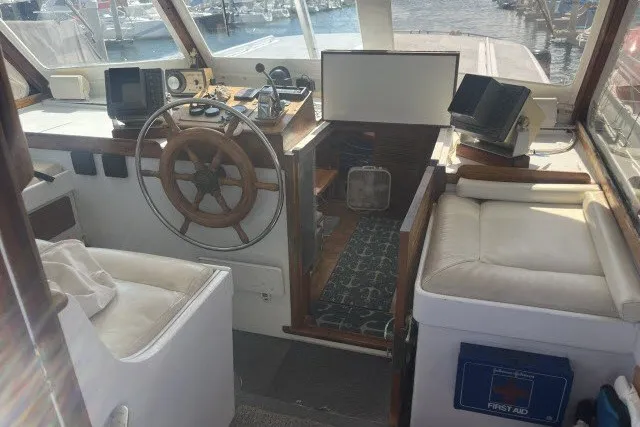 Slide: The Image of Interior of a 1983 Roughwater 41 boat with steering wheel and navigation equipment. - 25