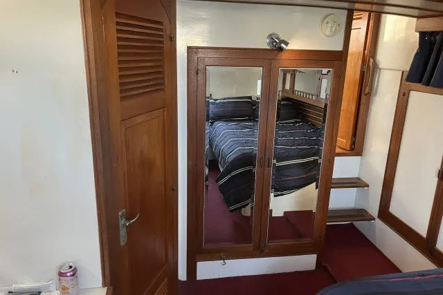 Slide: The Image of Interior of 1983 Roughwater 41 boat with wooden cabinetry and mirrored closet. - 21