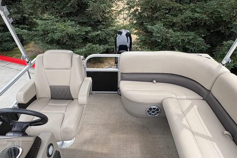 Slide: The Image of 2025 Sun Tracker Party Barge 16 DLX interior with beige seating and steering console. - 23
