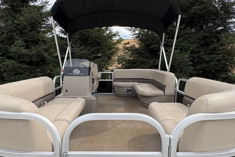 Slide: The Image of 2025 Sun Tracker Party Barge 16 DLX pontoon boat with beige seating and canopy. - 24
