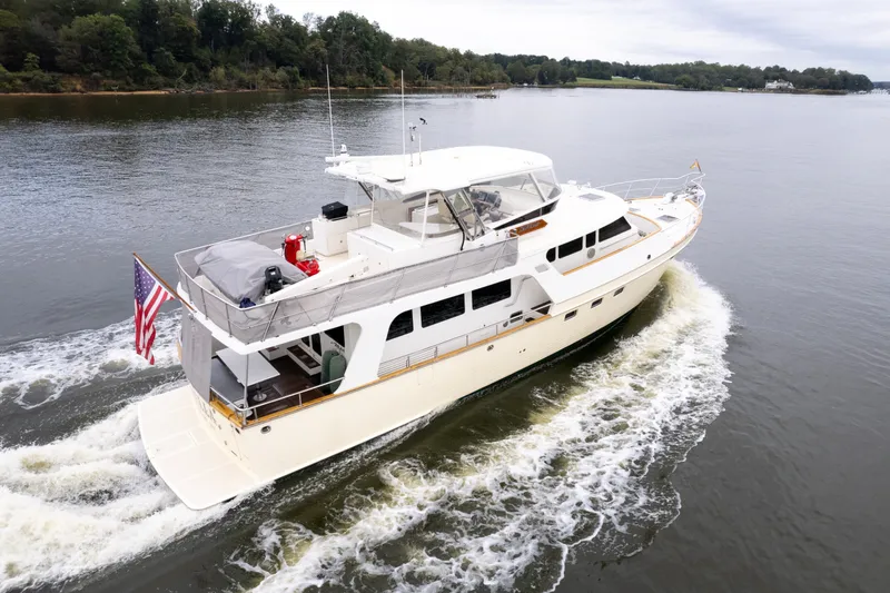 Slide: The Image of Luxurious 2009 Marlow 61C yacht cruising on a serene river with lush green shoreline. - 142
