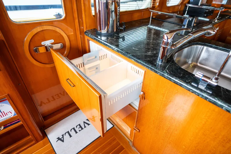 Slide: The Image of Luxury yacht kitchen with open drawer, Marlow 61C, 2009 model, featuring wood cabinetry and marble countertop. - 55