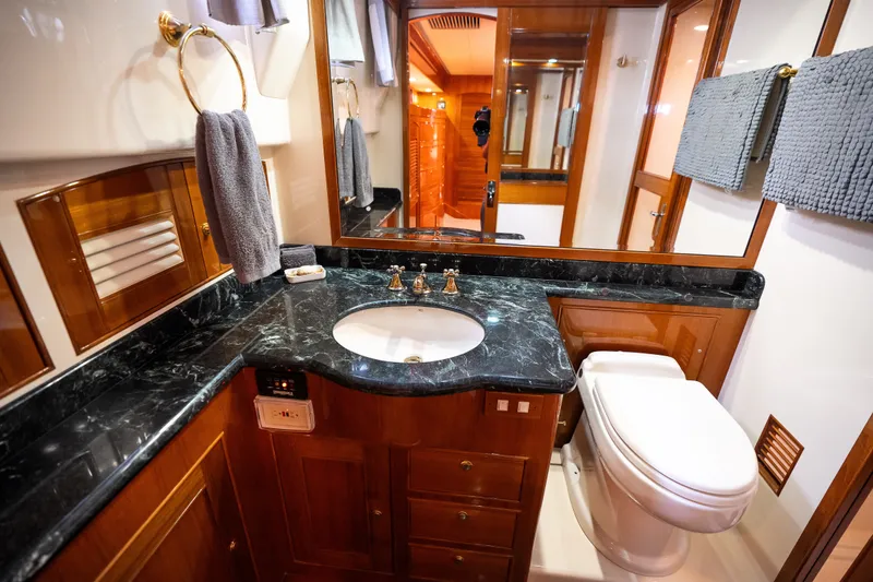 Slide: The Image of Luxurious Marlow 61C 2009 yacht bathroom with marble countertop and elegant wood cabinetry. - 112