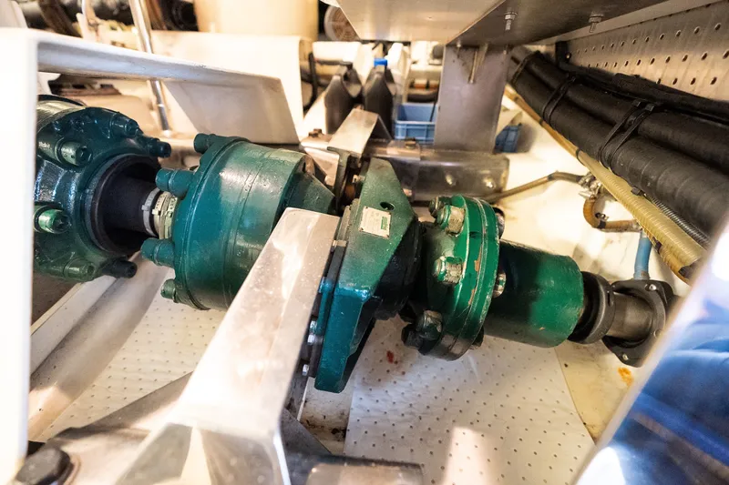 Slide: The Image of Engine room machinery of a 2009 Marlow 61C yacht, featuring green mechanical components. - 134
