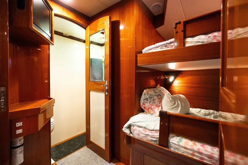 Slide: The Image of Cozy cabin interior with wooden bunk beds on a 2009 Marlow 61C yacht. - 89