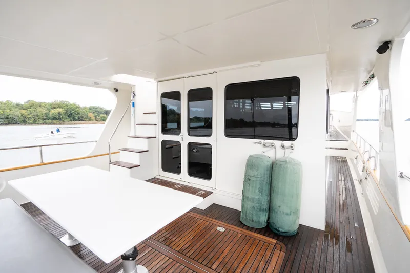 Slide: The Image of Spacious deck of 2009 Marlow 61C yacht with wooden flooring and outdoor seating. - 11