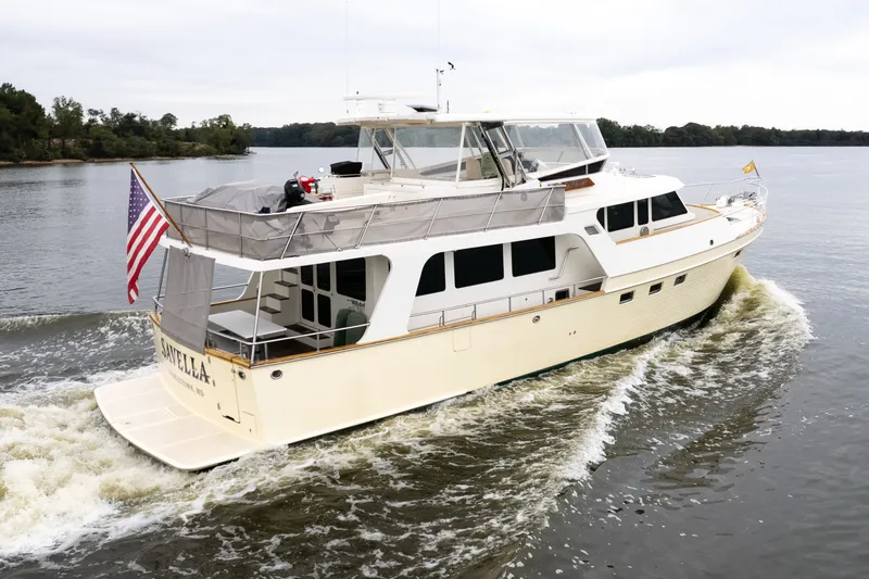 Slide: The Image of Luxury 2009 Marlow 61C yacht cruising on a serene river, displaying an American flag. - 4