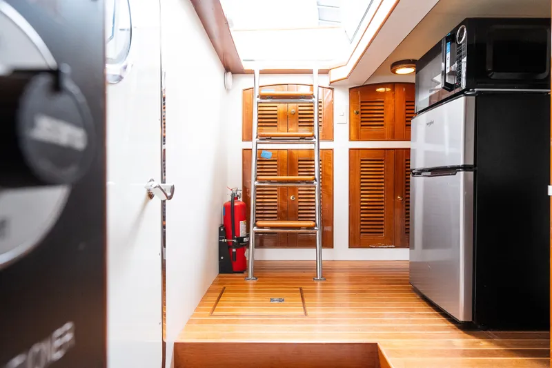 Slide: The Image of Interior of 2009 Marlow 61C yacht with wooden flooring, ladder, and modern appliances. - 123