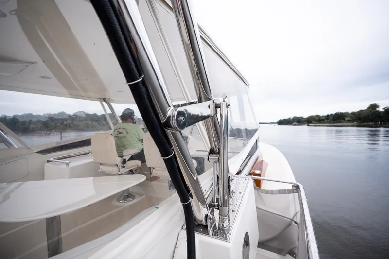 Slide: The Image of 2009 Marlow 61C yacht cruising on a calm river, featuring sleek design and spacious interior. - 80