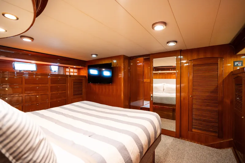 Slide: The Image of Luxurious cabin interior of 2009 Marlow 61C yacht with wood paneling and striped bedding. - 111