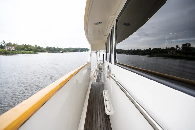 Slide: The Image of Side deck view of 2009 Marlow 61C yacht cruising on a calm river. - 25