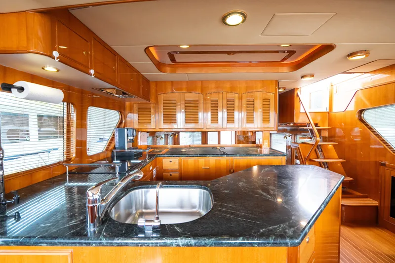 Slide: The Image of Luxurious kitchen interior of 2009 Marlow 61C yacht with sleek wood cabinetry and granite countertops. - 43
