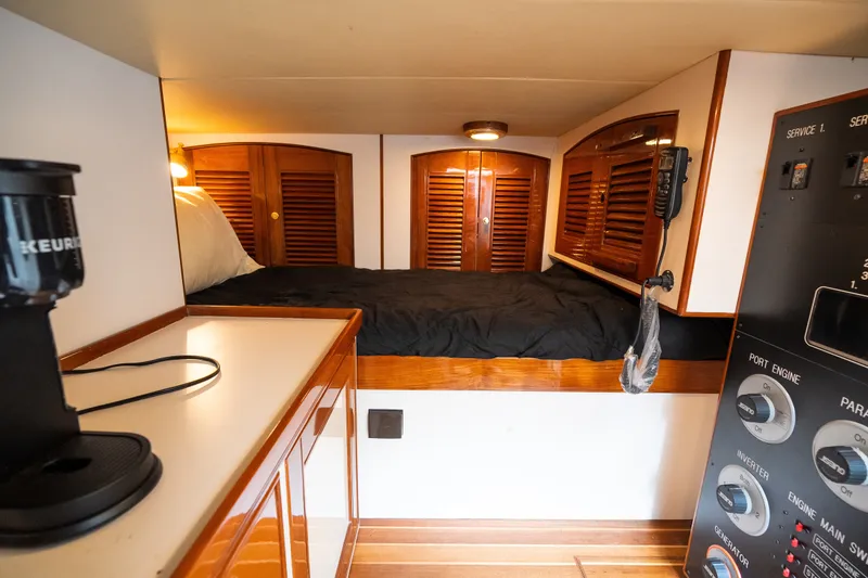 Slide: The Image of Cozy cabin interior of 2009 Marlow 61C yacht with bed, control panel, and coffee maker. - 126