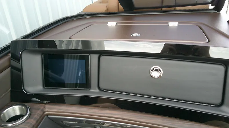 Slide: The Image of The image shows the dashboard of a Bennington 27 QXSBA boat with a screen and a closed compartment. - 14