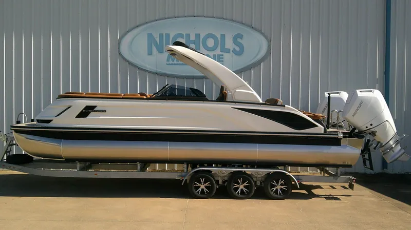 The Image of Bennington 27 QXSBA 2027: Sleek pontoon boat with modern design, on a trailer in front of a building. - 0