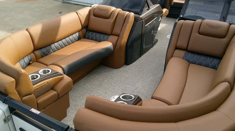 Slide: The Image of Luxurious seating area on a Bennington 27 QXSBA pontoon boat, featuring brown upholstery and cup holders. - 7