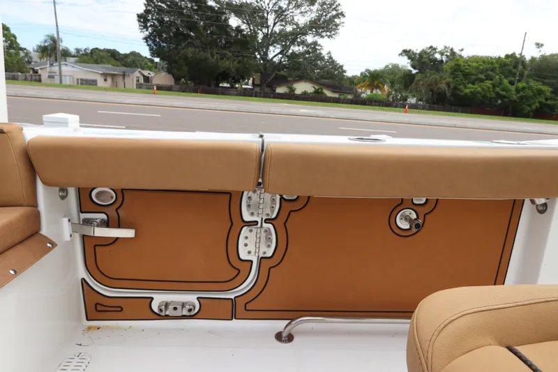 Slide: The Image of Interior view of a 2021 Sea Hunt Ultra 275SE boat, showcasing tan seating and storage compartments. - 12