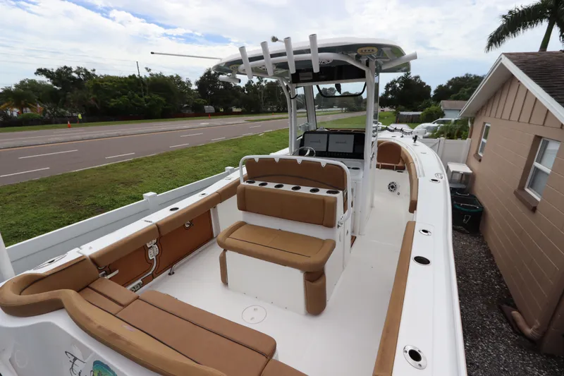 Slide: The Image of 2021 Sea Hunt Ultra 275SE boat with tan seating, parked near a road and house. - 8