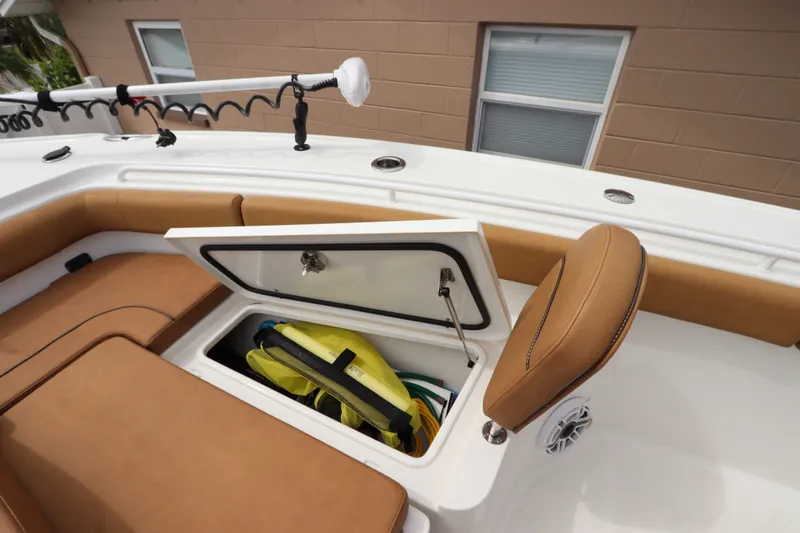 Slide: The Image of 2021 Sea Hunt Ultra 275SE boat with open storage compartment and brown seating. - 30