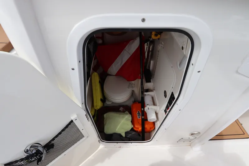 Slide: The Image of Storage compartment of 2021 Sea Hunt Ultra 275SE boat with safety equipment. - 38