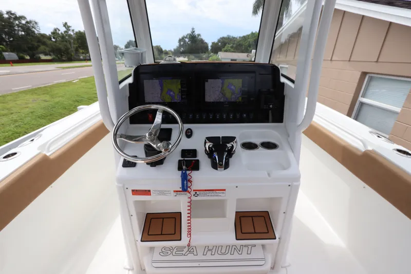 Slide: The Image of 2021 Sea Hunt Ultra 275SE boat dashboard with steering wheel and navigation screens. - 19