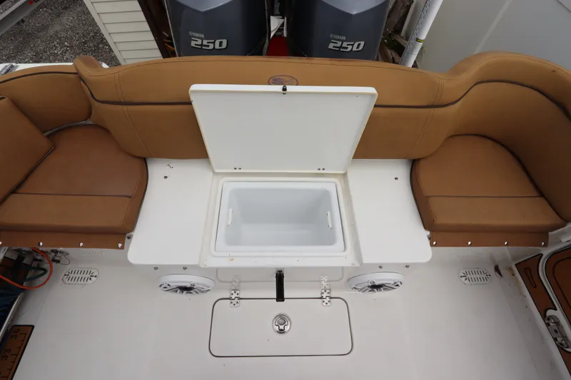 Slide: The Image of 2021 Sea Hunt Ultra 275SE boat interior with tan seating and open storage compartment. - 10