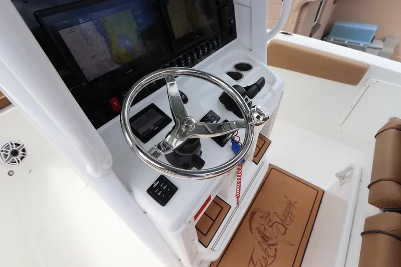 Slide: The Image of 2021 Sea Hunt Ultra 275SE boat helm with steering wheel and navigation displays. - 22