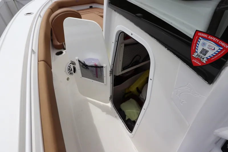 Slide: The Image of 2021 Sea Hunt Ultra 275SE boat interior with open storage compartment and safety check sticker. - 37