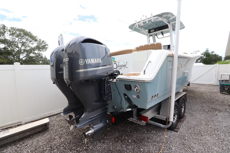 Slide: The Image of 2021 Sea Hunt Ultra 275SE boat with dual Yamaha engines on a trailer. - 2