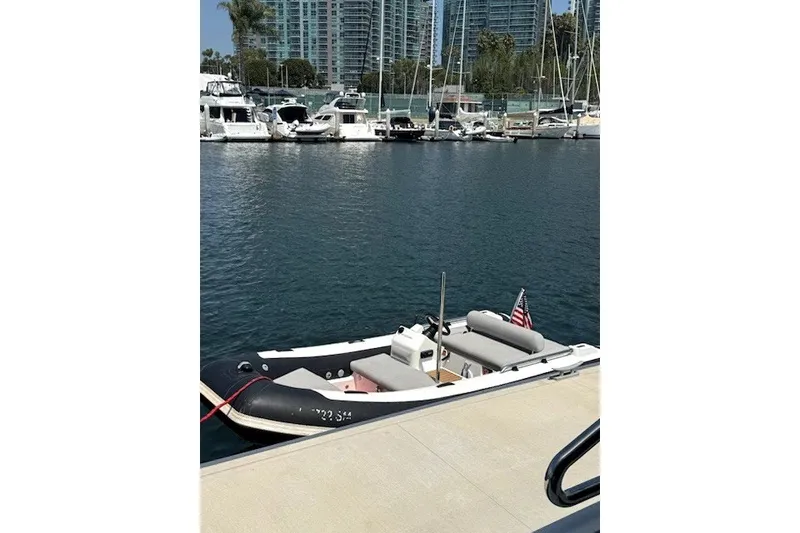 The Image of 2019 Williams Jet Tenders Sportjet 435 docked in a marina with yachts and skyscrapers. - 3