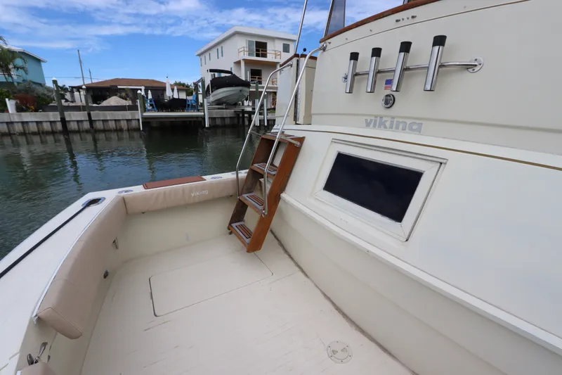 Slide: The Image of 1985 Viking 50 Cockpit Motor Yacht docked, showcasing spacious deck and elegant design. - 11