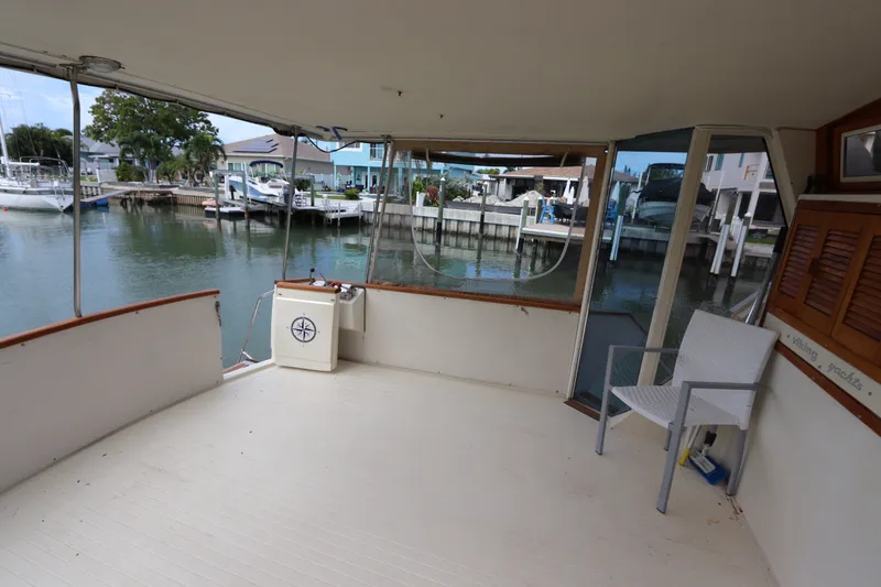 Slide: The Image of 1985 Viking 50 Cockpit Motor Yacht interior with marina view and seating area. - 5
