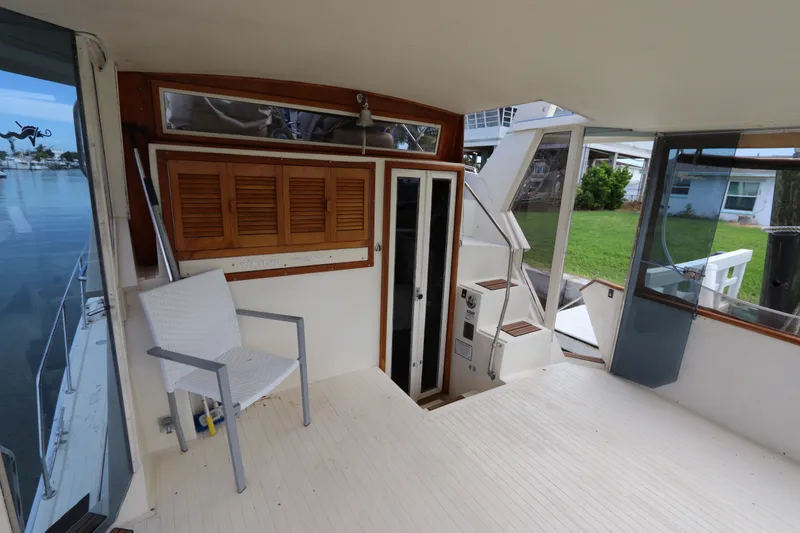 Slide: The Image of 1985 Viking 50 Cockpit Motor Yacht interior with white chair and wooden accents. - 12
