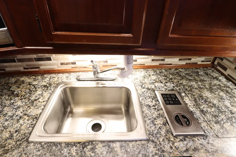 Slide: The Image of Stainless steel sink and control panel on granite countertop in 1985 Viking 50 Cockpit Motor Yacht. - 33