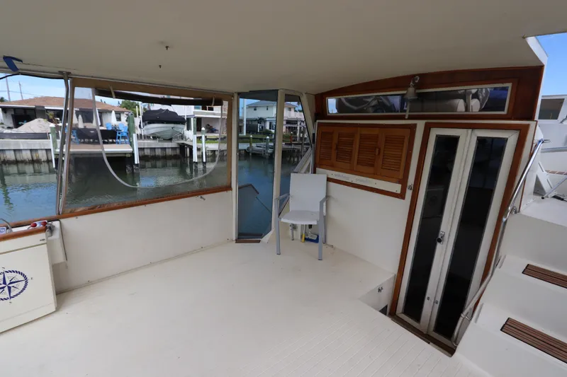 Slide: The Image of 1985 Viking 50 Cockpit Motor Yacht interior with waterfront view and seating area. - 3