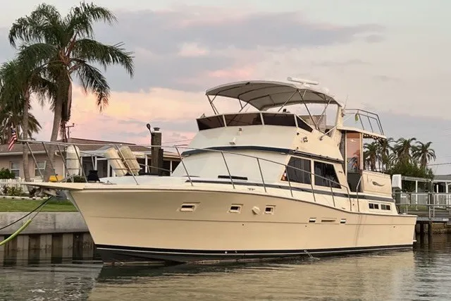 The Image of 1985 Viking 50 Cockpit Motor Yacht docked at sunset with palm trees in the background. - 0