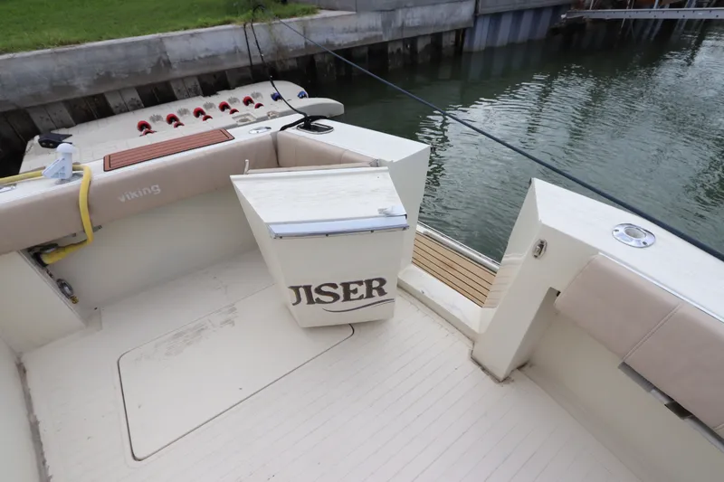 Slide: The Image of 1985 Viking 50 Cockpit Motor Yacht docked, featuring spacious deck and seating area. - 9