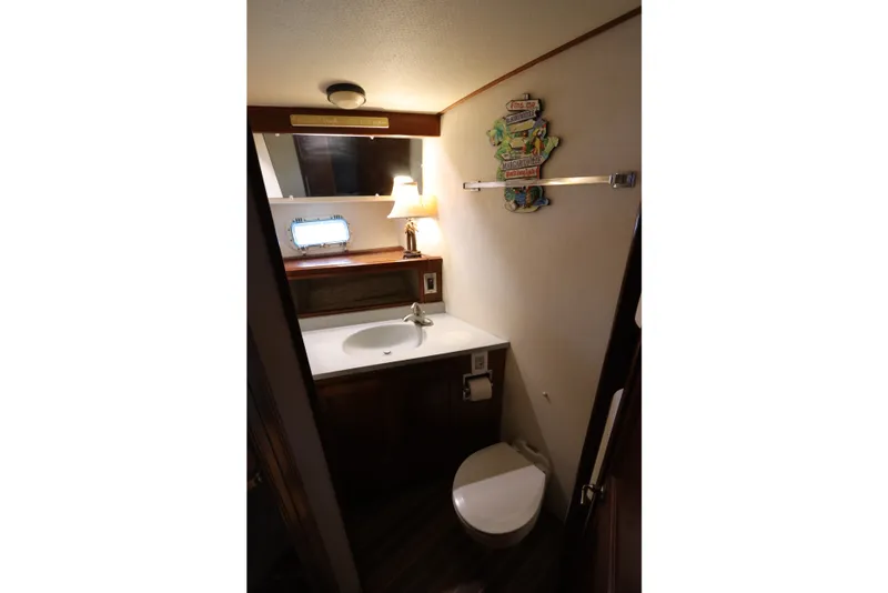 Slide: The Image of Bathroom interior of 1985 Viking 50 Cockpit Motor Yacht with sink, toilet, and decor. - 41